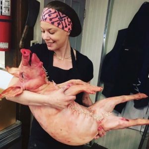 Disgusting insensitive picture of woman holding dead pig as a baby