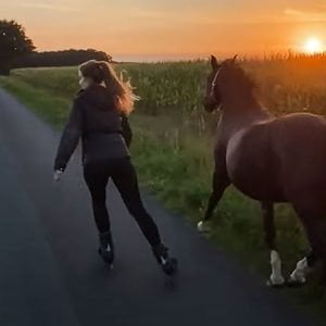 Woman rollerblades with her horse