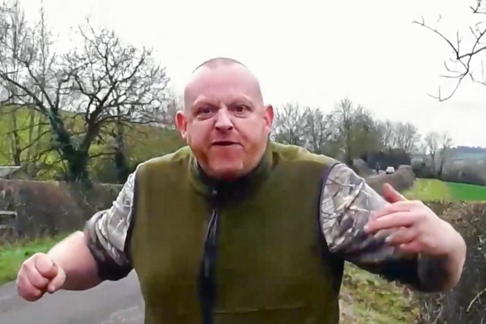 Violent, aggressive foxhunt worker intimidates female hunt saboteur with ranting and raving and a clenched fist. She stands her ground.